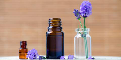 Benefits of Essential Oils & Aromatherapy Lavender essential oil bottles and fresh flowers for aromatherapy.