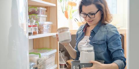 Woman selecting food from her organized kitchen pantry.