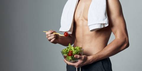 Physical Benefits of Creatine a young and muscular athlete eating a salad