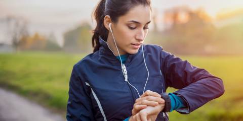 The Benefits of Fitness-Gadgets  a woman walking the park, checking her smartwatch