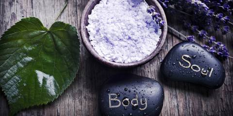 A green leaf with healing stones, a bowl with lavender herb salt and dry French lavender.