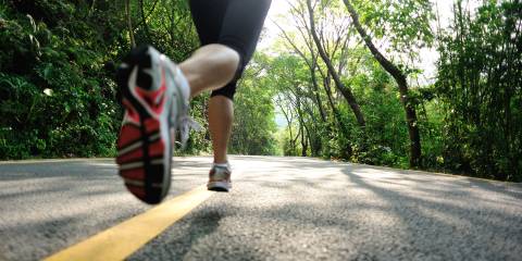 Nutrition for Distance Runners a woman running down a narrow road in the forest