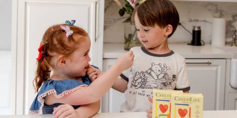 two toddlers sharing children's vitamins