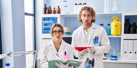 two medical researchers looking very confused and slightly guilty