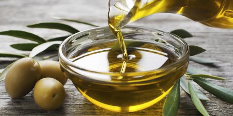 Olive oil bring poured into a glass bowl. 