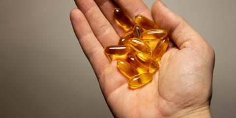 Hand holding omega-3 vitamins. 
