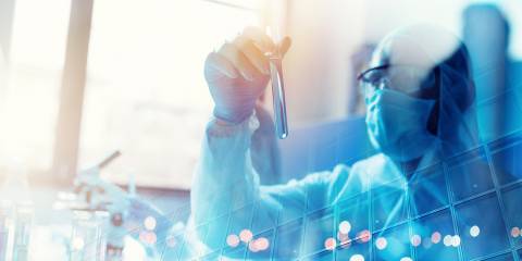 Doctor studying a vial during covid-19 coronavirus research.