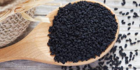 Black cumin seeds in a wooden spoon