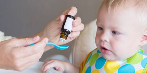 a mother giving a liquid supplement to her baby