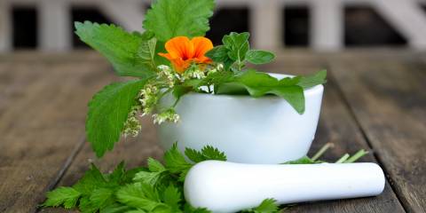 fresh herbs in a mortar and pestle