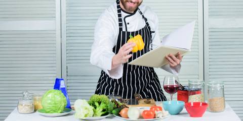 a cook reading kitchen tips from a guidebook