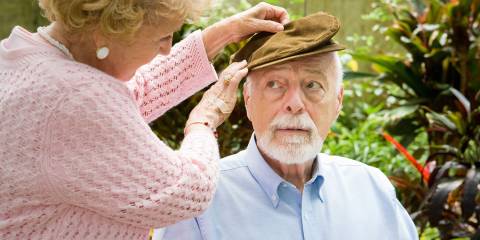 A senior woman putting a hat on her husband