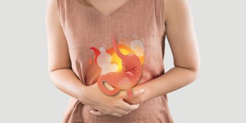 a woman in pain due to a burning cartoon stomach