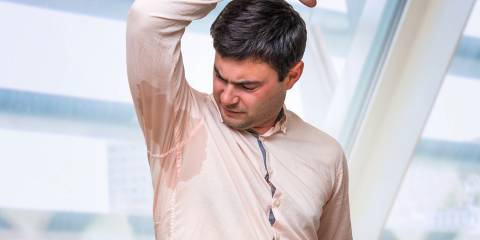 a man sweating heavily through his dress shirt