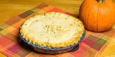 a turkey pot pie next to a pumpkin