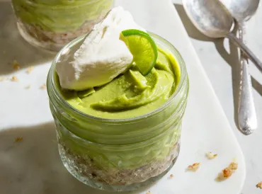 a small mason jar lined with nuts and filled with key lime pie filling