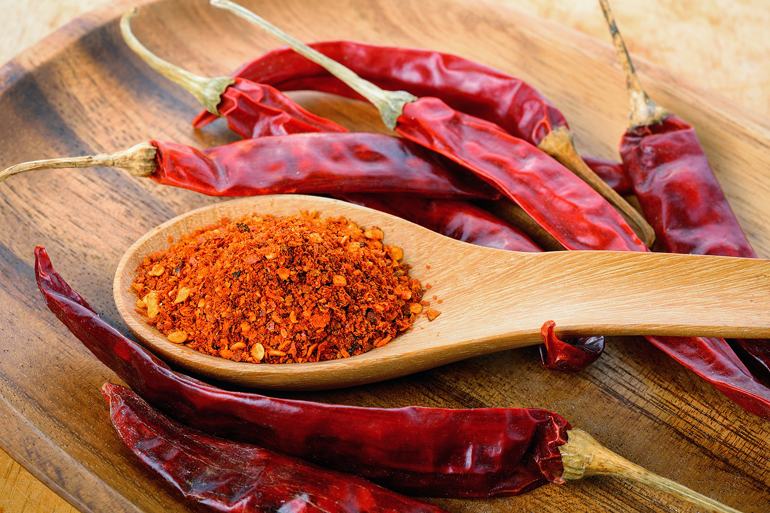 cayenne peppers and a spoon of dried cayenne powder