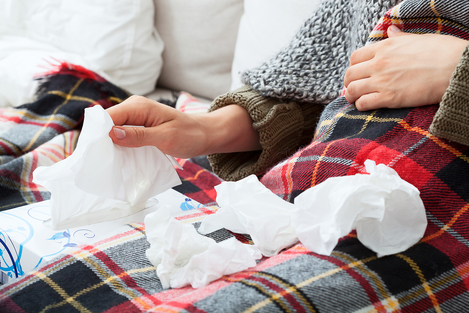 Runny Nose a woman with a pile of used tissues
